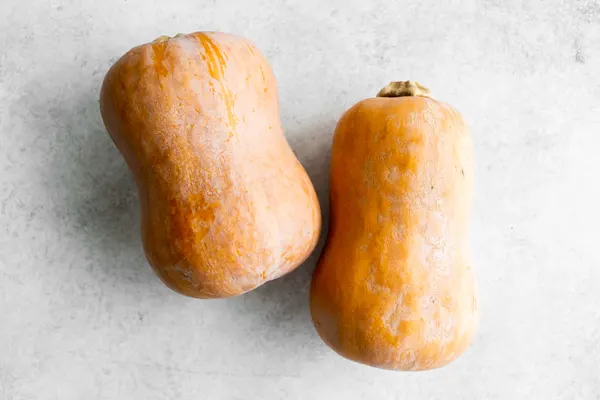two honeynut squash laying on a table. 