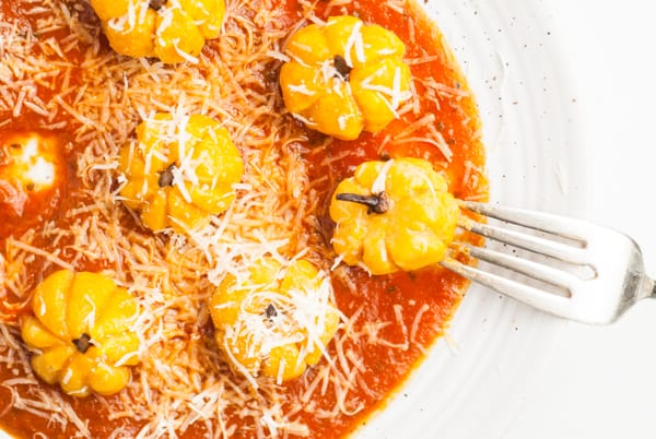 Pumpkin Shaped Gnocchi on a plate sprinkled with cheese. 