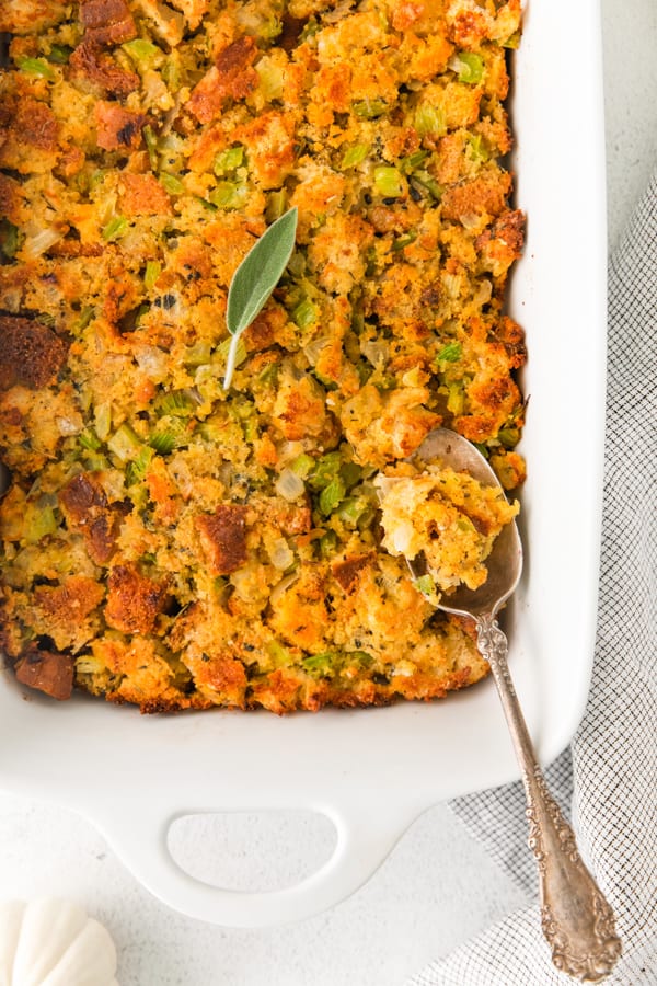 Sage and Cornbread Stuffing in a dish with a spoon. 
