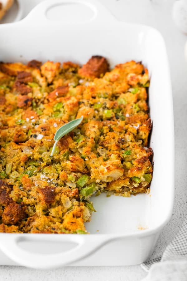 Sage and Cornbread Stuffing in a dish with a scoop taken out. 