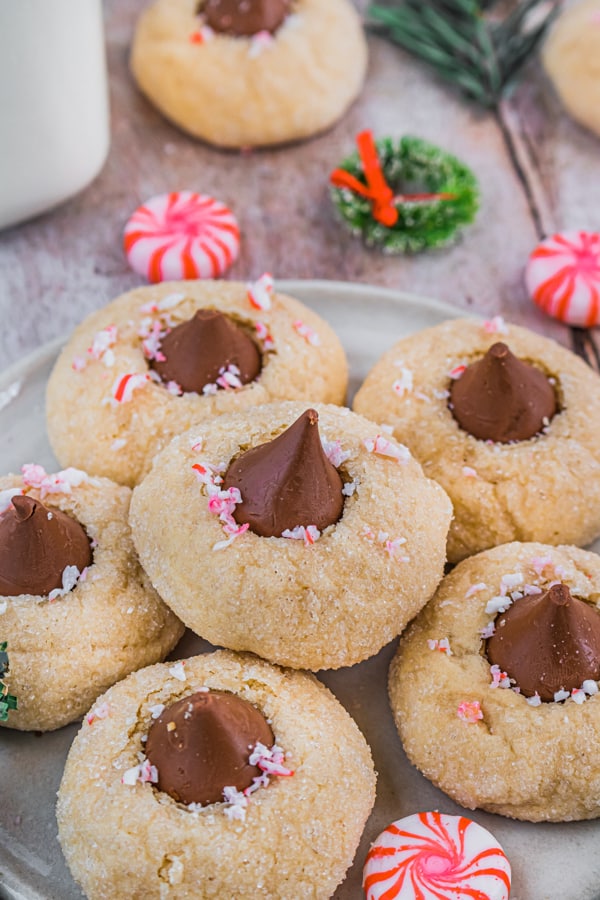 Peppermint Kiss Cookies on a plate sprinkled with crushed candy canes. 