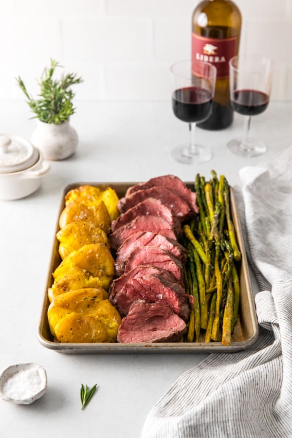 Sheet pan Christmas dinner served with red wine. 