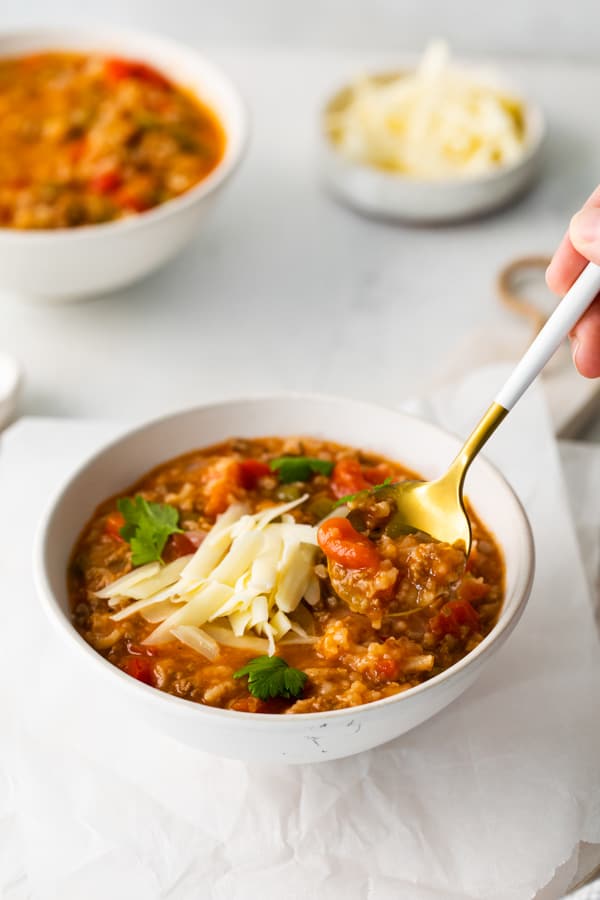 Instant Pot Stuffed Pepper Soup in a bowl with a spoon taking a spoonful. 