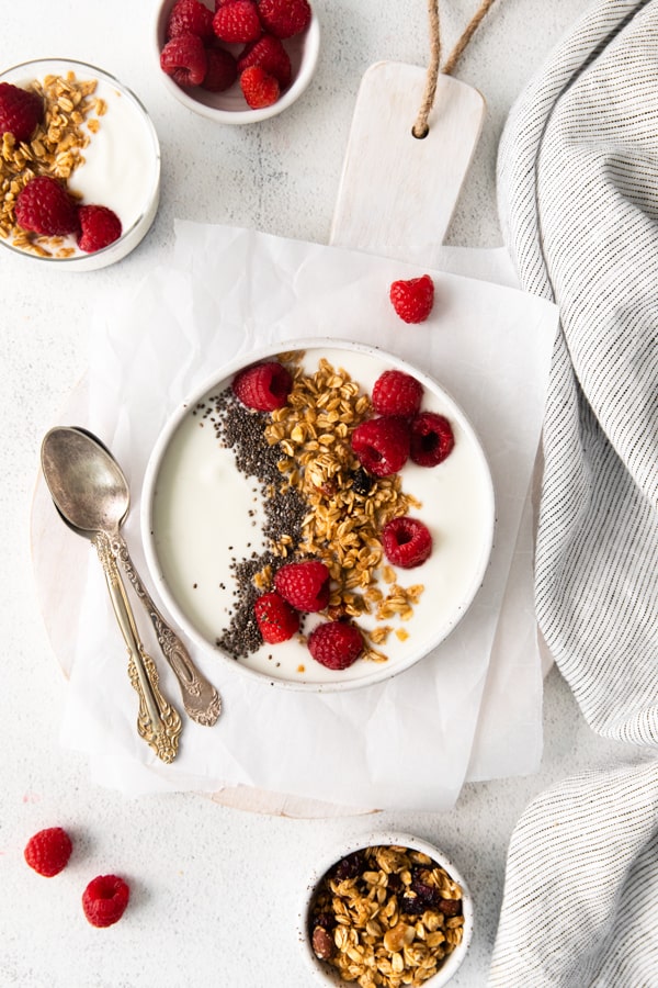Instant Pot Yogurt served in a bowl with raspberries and granola. 