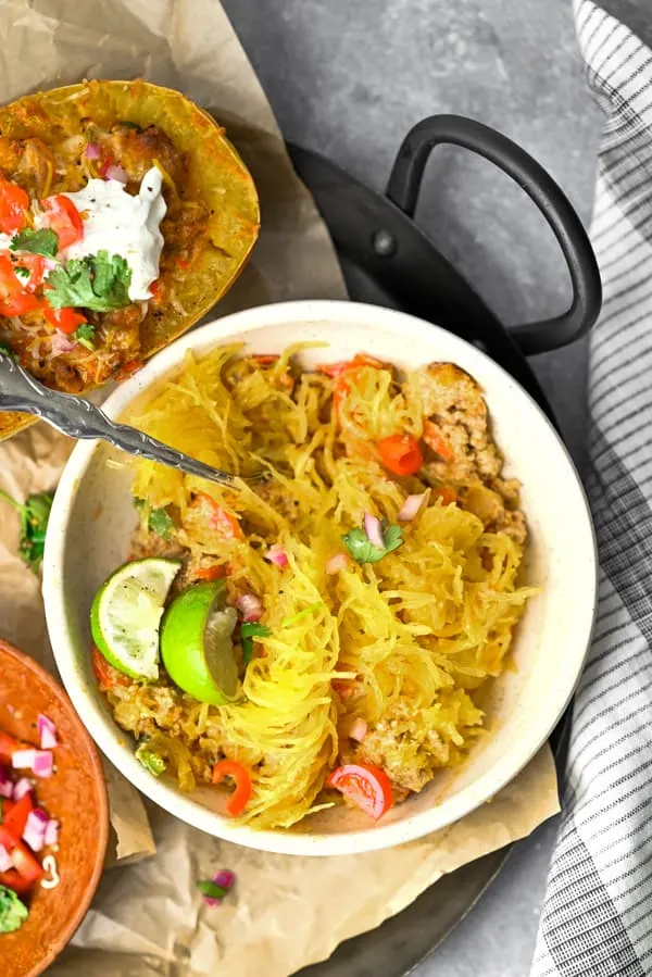 Ground Chicken Fajita Spaghetti Squash scooped into a bowl and served with lime. 
