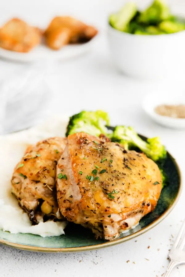 Air Fryer Chicken Thighs on a plate with vegetables. 