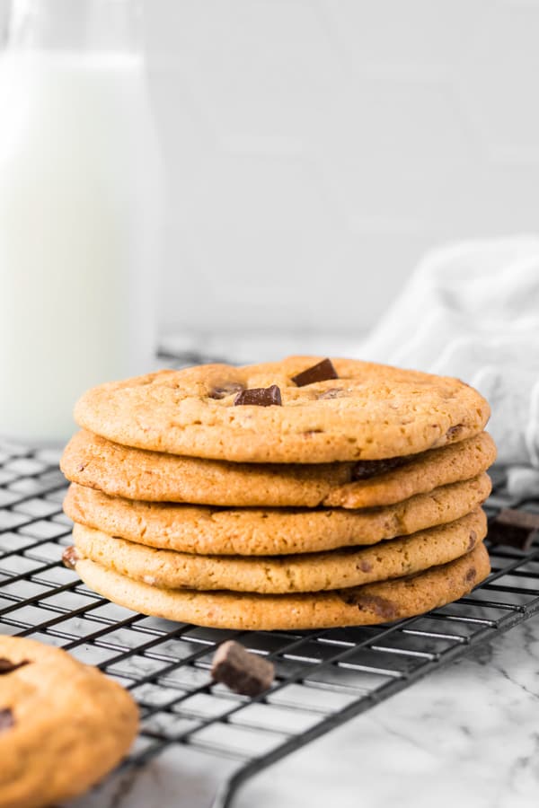 Caramel Chocolate Chip Cookies stacked on a cooling rack. 