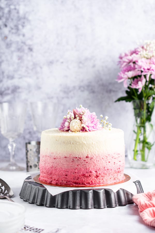 Strawberry Coconut Layer Cake on a cake stand. 
