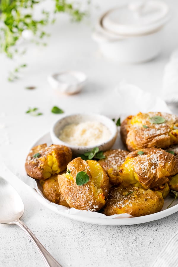 Air Fryer Smashed Potatoes topped with fresh herbs and parmesan cheese. 