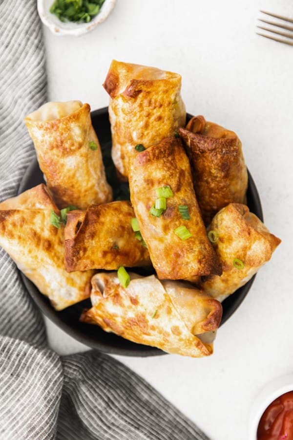 Air Fryer Cheeseburger Egg Rolls topped with green onions. 