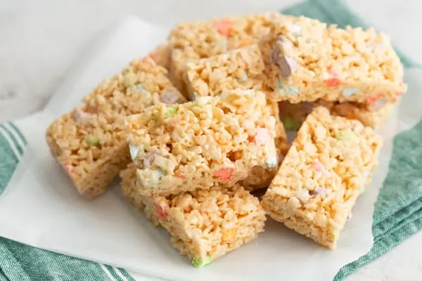 Lucky Charms Rice Krispie Treats cut on parchment paper. 