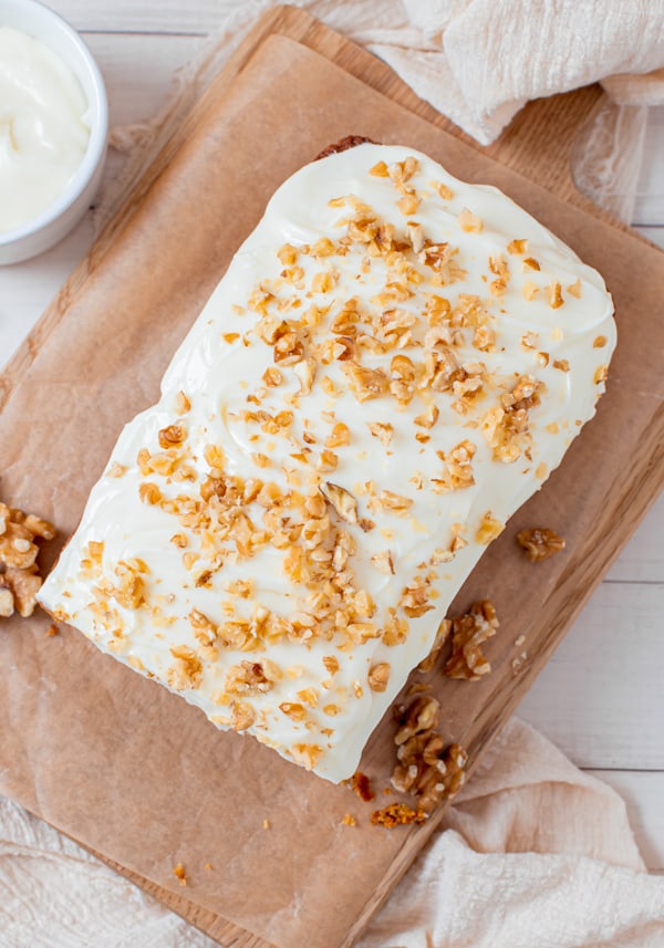 Carrot Cake Loaf Cake topped with frosting and walnuts. 