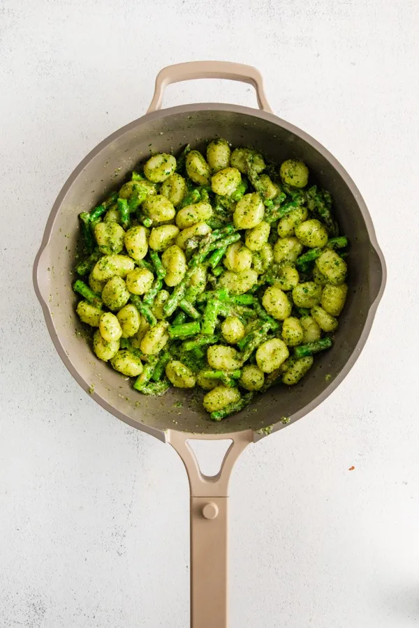 Pesto Gnocchi with Asparagus in a skillet. 