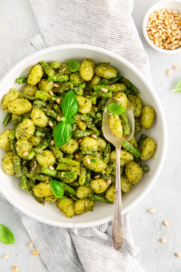 Pesto Gnocchi with Asparagus in a bowl with a spoon. 