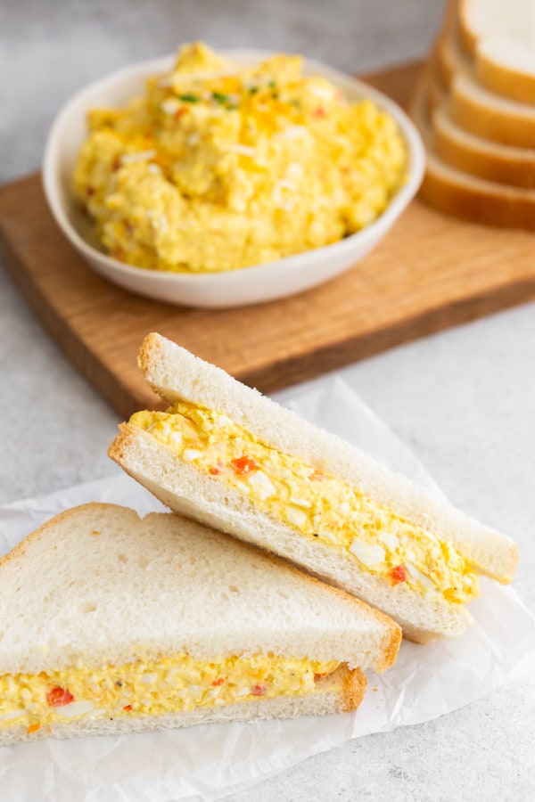 Pimento Cheese Egg Salad served on white bread and cut in half. 