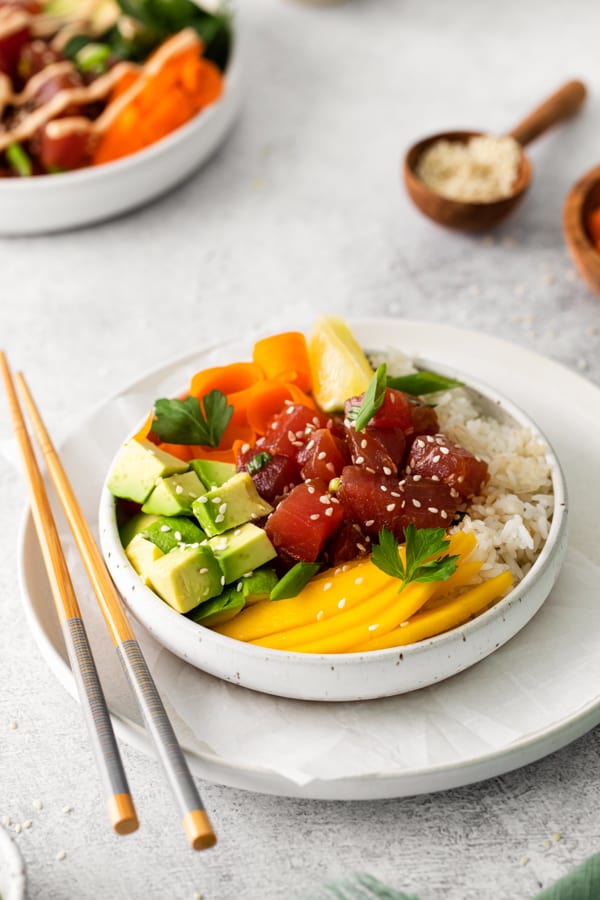 Tuna Poke Bowl in a bowl with rice, avocado, mango, and pickled vegetables. 