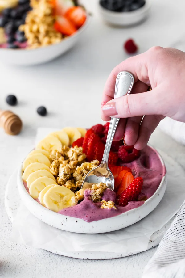 A spoon taking a bite out of a Acai Bowl. 