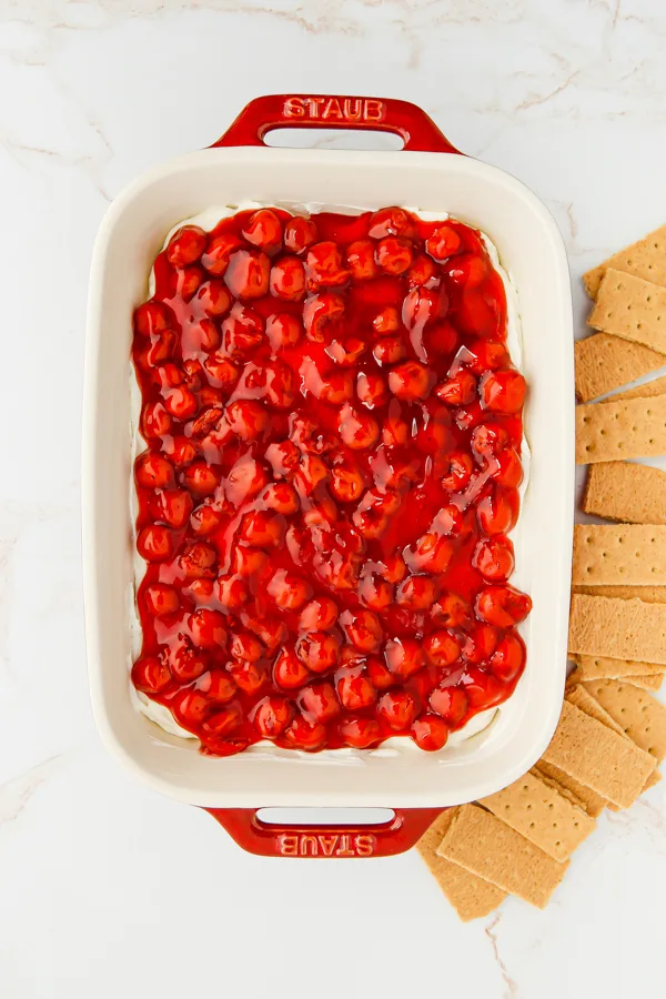 Cherry Cheesecake Dip in a dish with graham crackers on the side. 