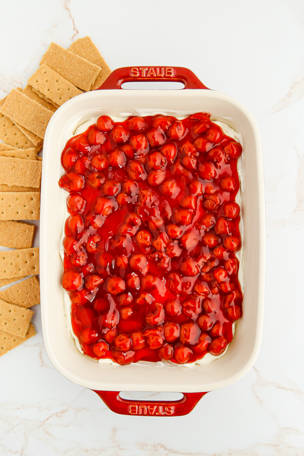 Cherry Cheesecake Dip served in a dish with graham crackers served alongside. 