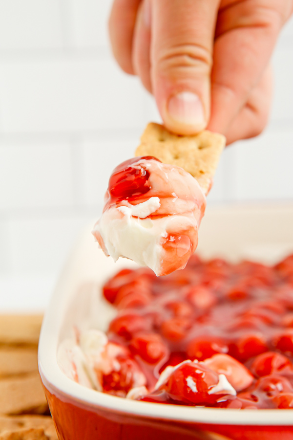 Cherry Cheesecake Dip being scooped out of the dish. 