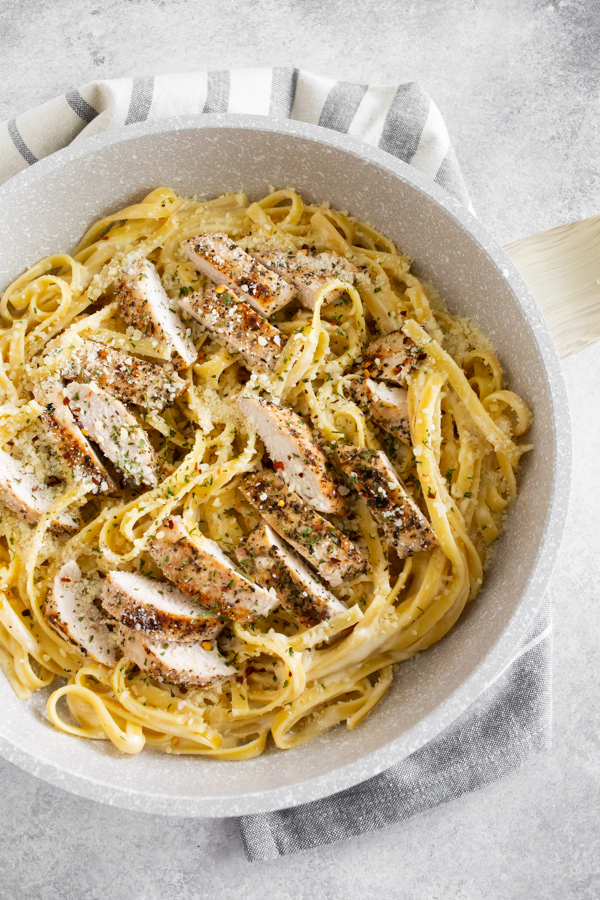 Chicken Fettuccine Alfredo in a pan with chicken on top. 