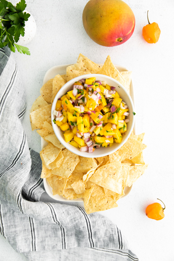 Mango Habanero Salsa in a bowl with corn chips served alongside. 