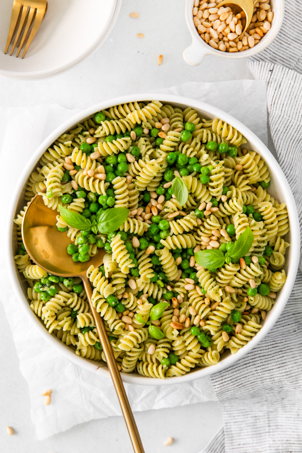 Pesto Pasta Salad in a large bowl with a serving spoon. 