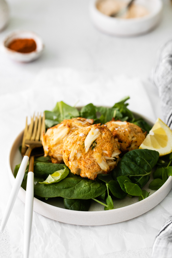 Air Fryer Crab Cakes set on a plate with mixed greens. 