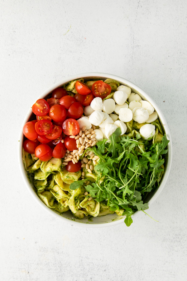 Pesto Tortellini Salad ingredients in a bowl. 