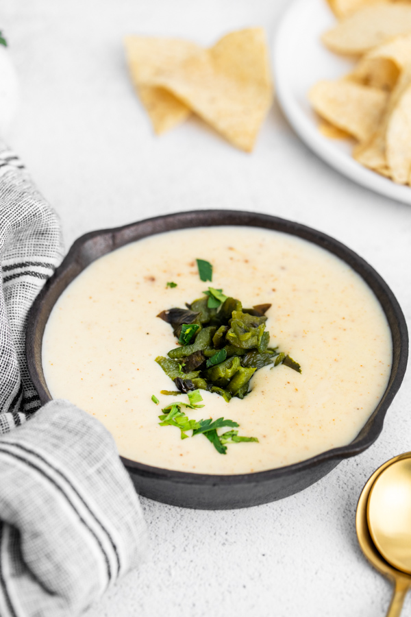 Roasted Poblano Queso in a dish topped with peppers. 