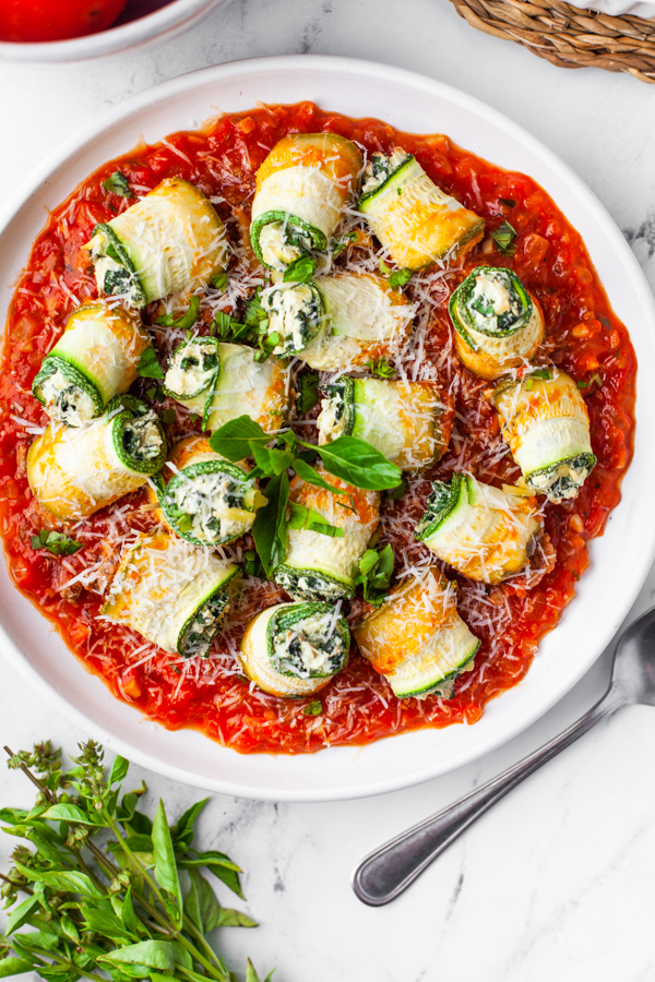 Zucchini Lasagna Rolls on a plate garnished with basil. 