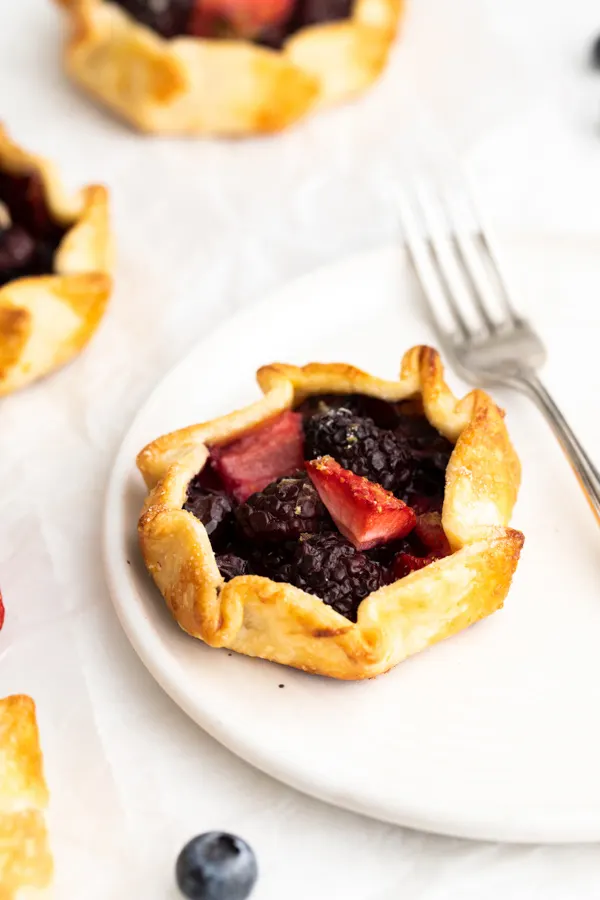 Mini Berry Galettes served on a plate with a fork. 