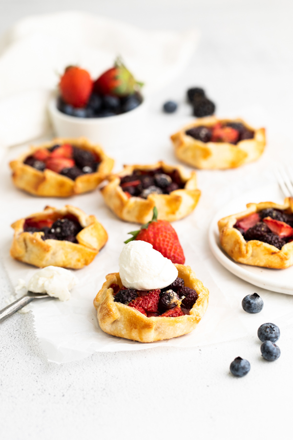 Mini Berry Galettes on a table with a scoop of ice cream. 