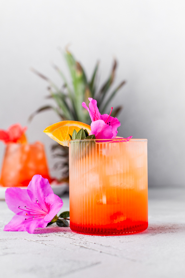 Pineapple Rum Punch topped with an edible flower. 
