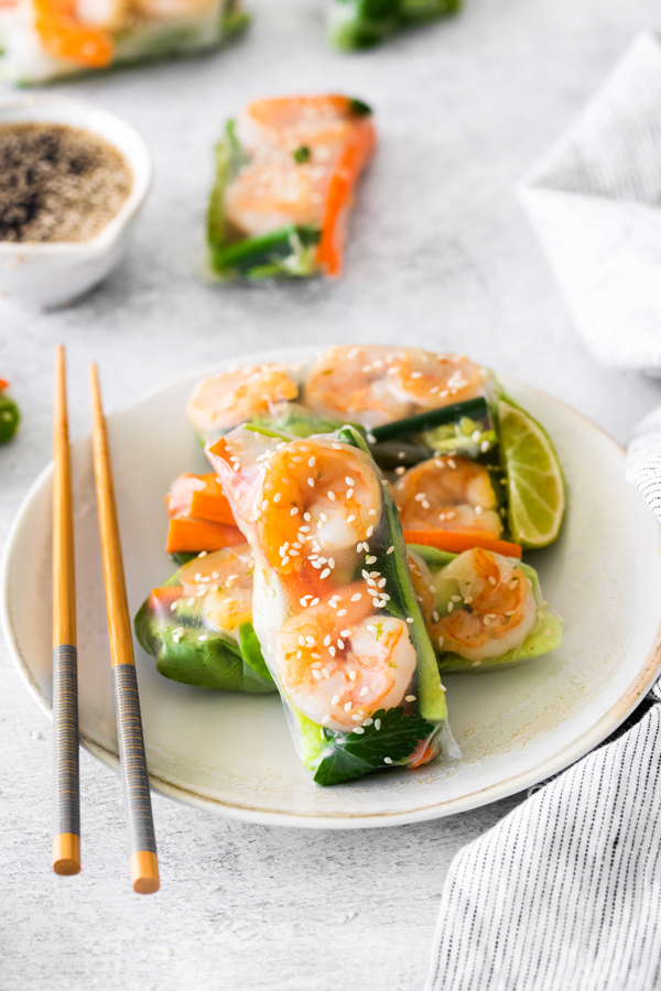 Shrimp Summer Rolls on a plate sprinkled with sesame seeds. 