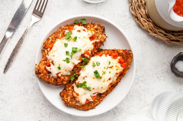 Air Fryer Chicken Parmesan sitting on a white plate. 