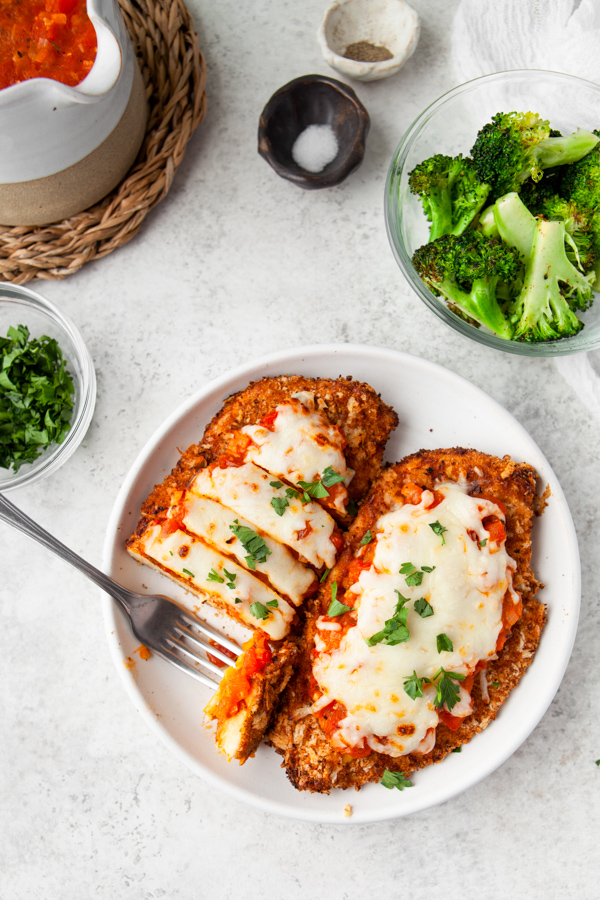 Air Fryer Chicken Parmesan on a white plate with a fork. 