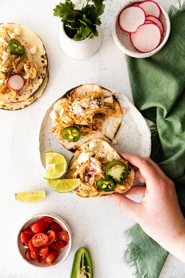 A hand holding a Instant Pot Pulled Chicken Taco. 