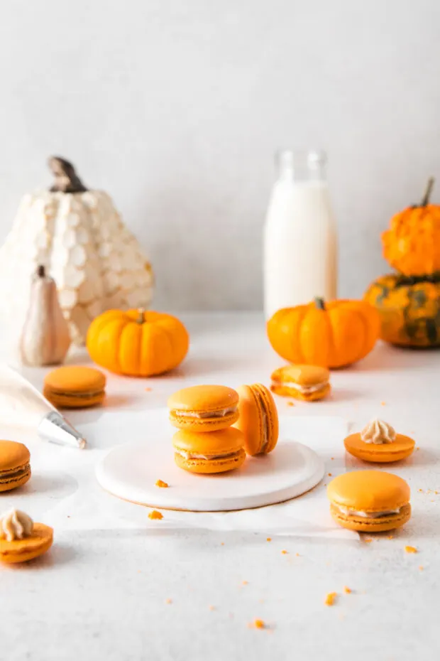 Pumpkin Spice Macarons stacked on a table. 