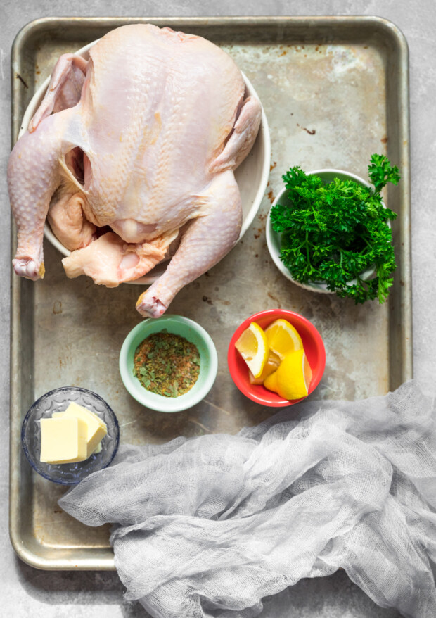 Ingredients to make Air Fryer Whole Chicken sitting on a sheet pan. 