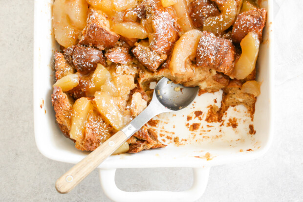 Apple Pie Baked French Toast in a dish with spoon sitting in the dish. 