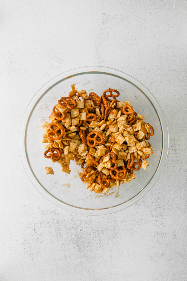 Chex cereal and pretzels tossed in brown sugar in a bowl. 