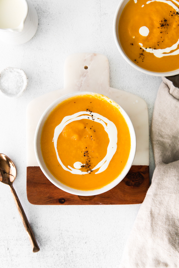Instant Pot Butternut Squash Soup drizzled with heavy cream and pepper. 