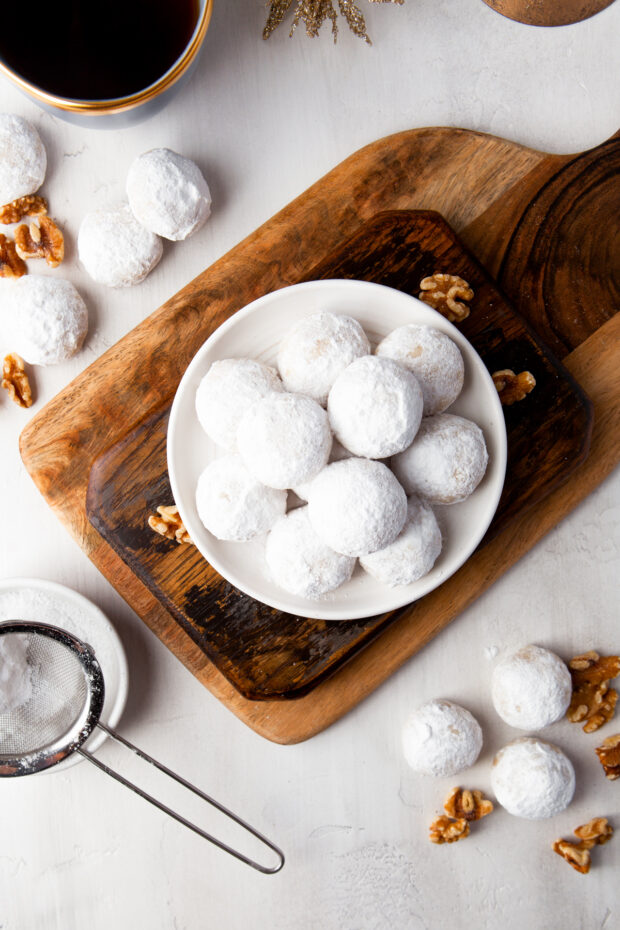 Snowball Cookies on a plate rolled in powdered sugar. 