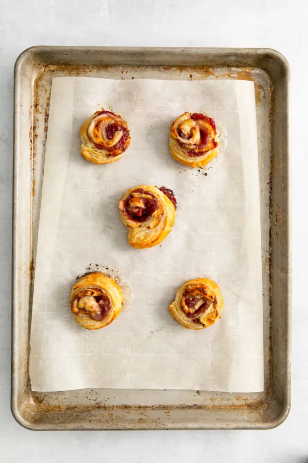 Cranberry Brie Pinwheels baked on a sheet pan. 