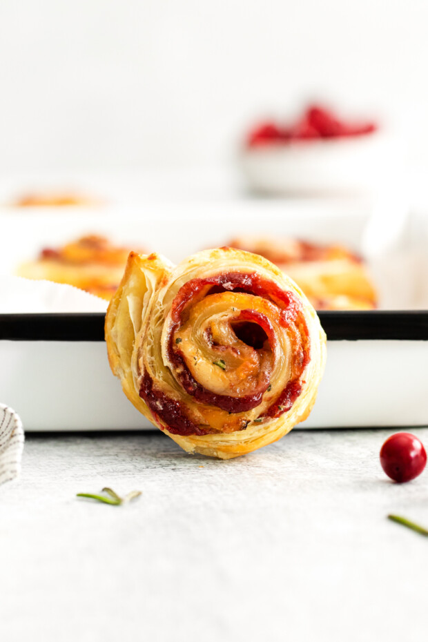 Cranberry Brie Pinwheels sitting against a tray to show the filling. 