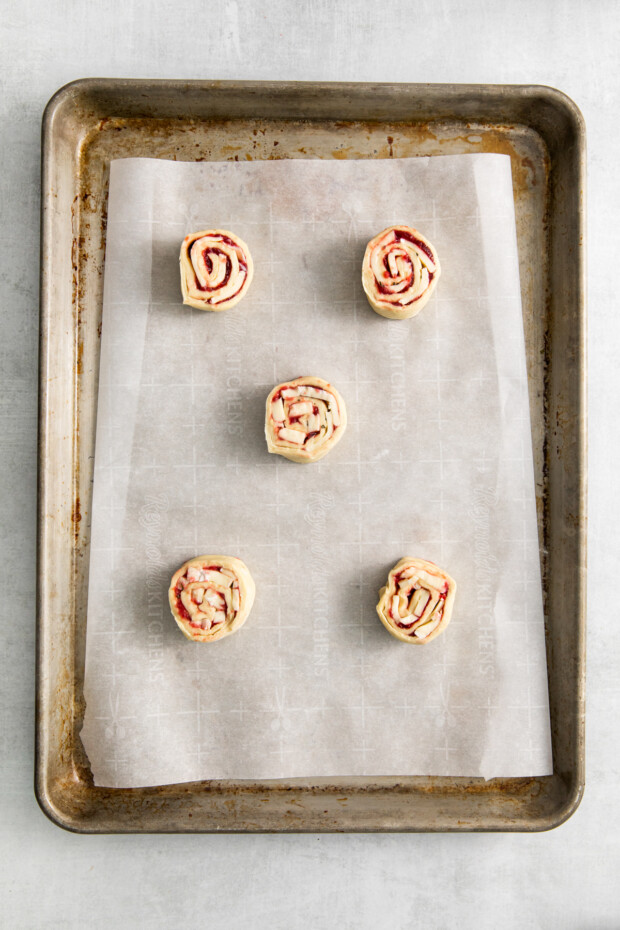 Cranberry Brie Pinwheels uncooked on a sheet pan. 