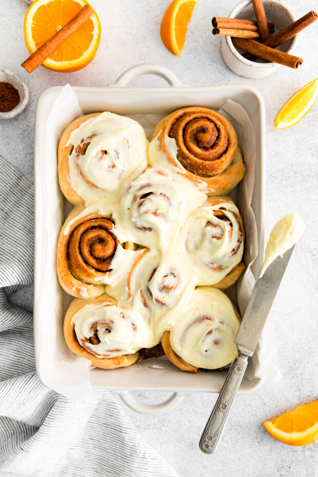 Spiced Orange Cinnamon Rolls in a dish topped with frosting. 