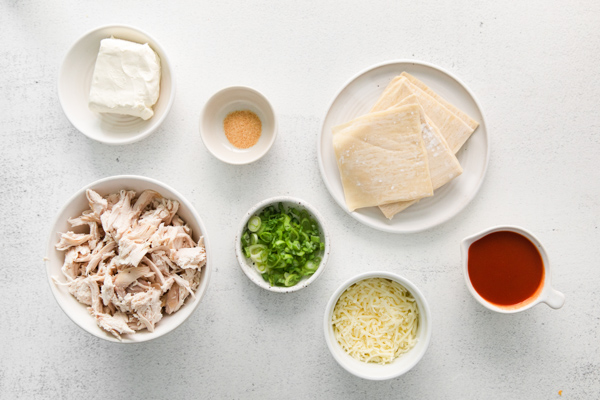 Ingredients to make Air Fryer Buffalo Chicken Wontons sitting on a table. 