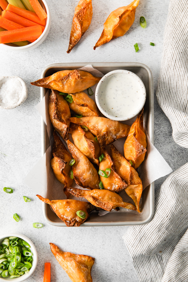 Air Fryer Buffalo Chicken Wontons on a serving tray with dip. 